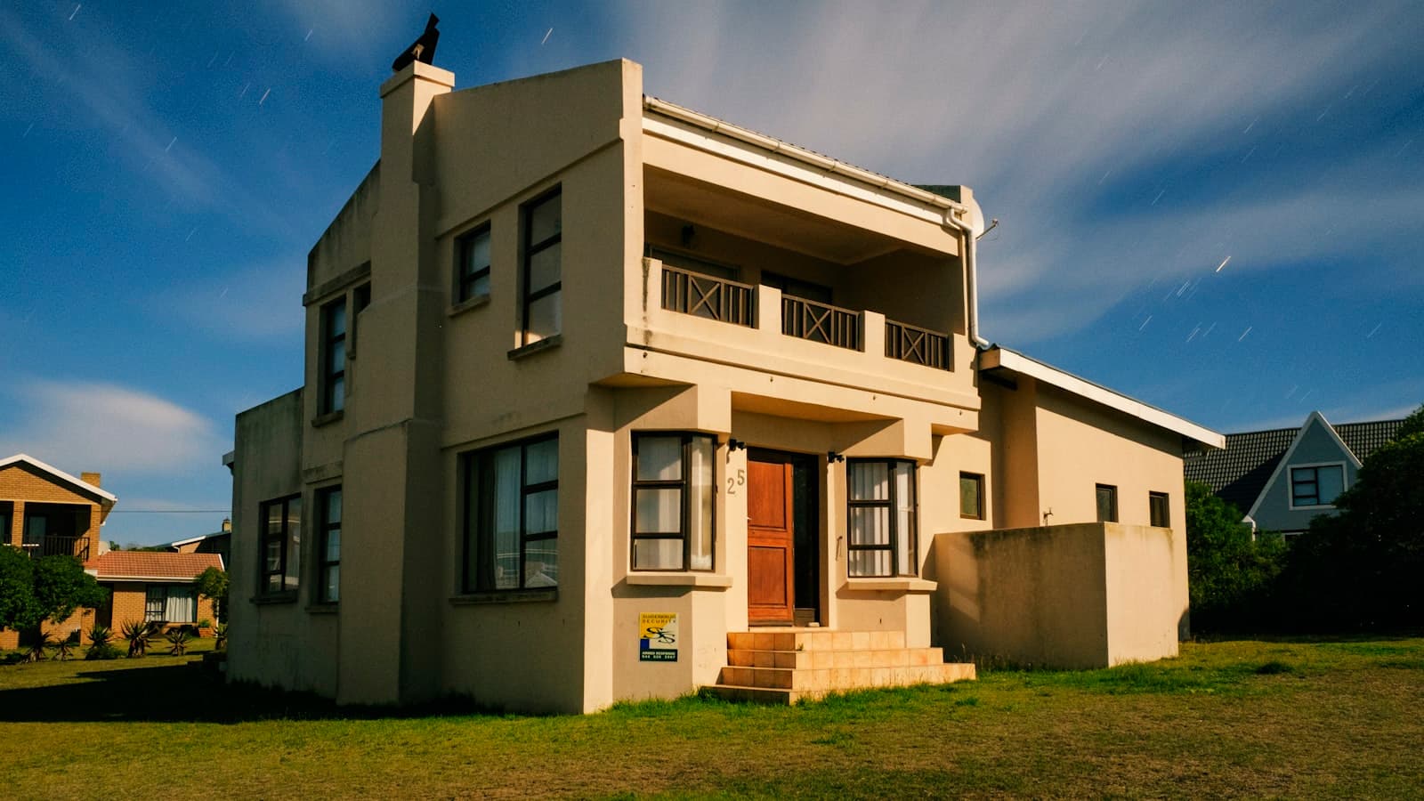 A double-storey suburban South African house exterior at dusk